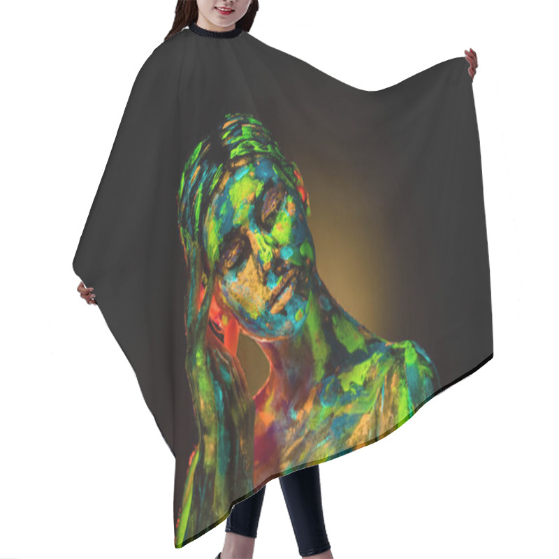 Personality  portrait of beautiful woman with colorful ultraviolet paints on body on black backdrop hair cutting cape
