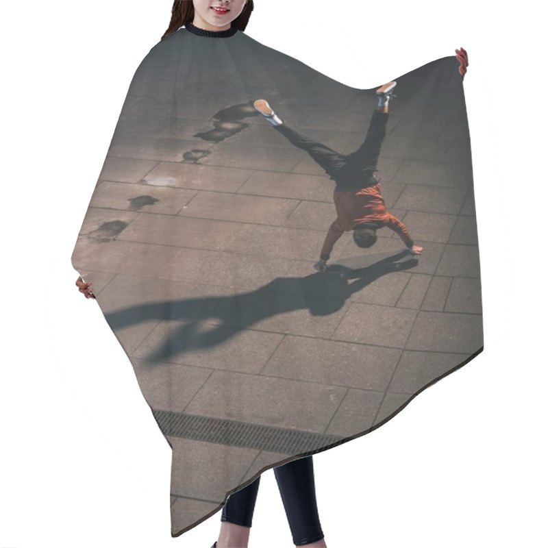 Personality  high angle view of skateboarder riding upside down on hands hair cutting cape