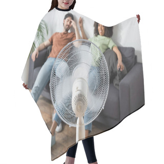 Personality  Blurred Interracial Man And Woman Sitting On Couch Near Electric Fan In Living Room  Hair Cutting Cape