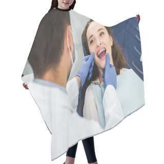Personality  Selective Focus Of Cheerful Woman In Braces Opening Mouth During Examination Of Teeth Near Dentist Hair Cutting Cape