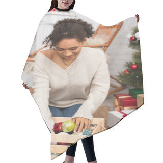 Personality  African American Woman Looking At Box With Christmas Balls Near Gifts At Home  Hair Cutting Cape