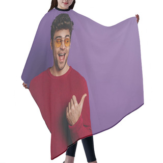 Personality  Cheerful Young Man Pointing With Thumb And Looking Away On Purple Background Hair Cutting Cape