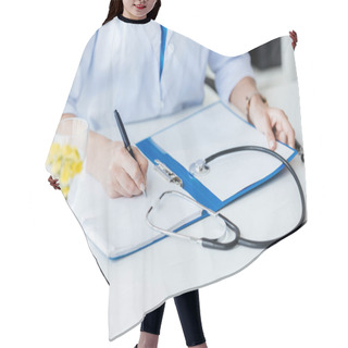 Personality  Cropped Image Of Female Doctor Writing In Clipboard At Table With Stethoscope In Office  Hair Cutting Cape