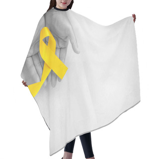 Personality  Hand Holding Yellow Ribbon On White Background, Copy Space. Bone Cancer, Sarcoma Awareness, Childhood Cancer, Cholangiocarcinoma, Gallbladder Cancer, World Suicide Prevention Day. Health Concept. Hair Cutting Cape