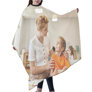 Personality  Positive Teacher Hugging Pupil Near Didactic Materials In Class In Montessori School Hair Cutting Cape