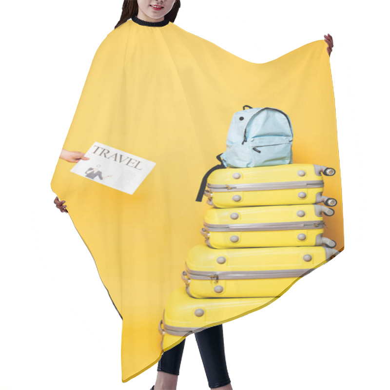 Personality  Cropped View Of Woman Holding Travel Newspaper Near Blue Backpack On Travel Bags On Yellow Hair Cutting Cape