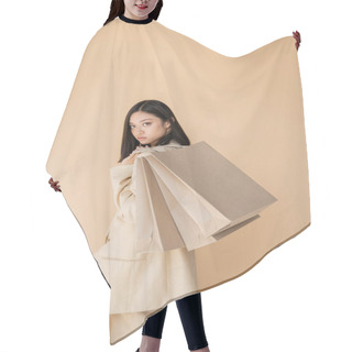 Personality  Young And Fashionable Asian Woman With Shopping Bags Looking At Camera Isolated On Beige Hair Cutting Cape