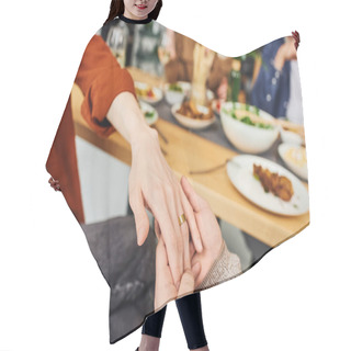 Personality  Cropped View Of Gay Man Holding Hand On Boyfriend In Wedding Ring Near Blurred Supper And Parents At Home Hair Cutting Cape