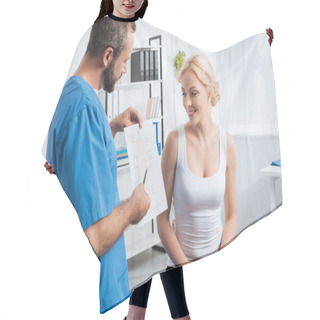 Personality  Physiotherapist Showing Human Body Scheme To Woman On Massage Table In Hospital Hair Cutting Cape
