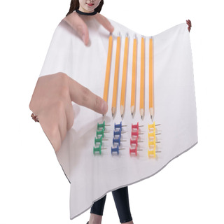 Personality  A Person's Hand Arranging Pencils And Multi Colored Pushpins In A Row On White Background Hair Cutting Cape