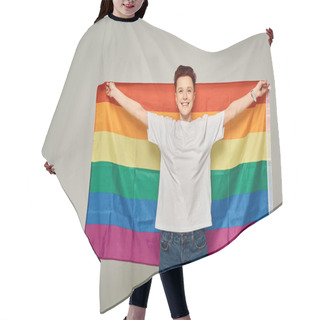 Personality  Cheerful Redhead Bigender Person In White T-shirt Standing With LGBT Flag On Grey Backdrop Hair Cutting Cape