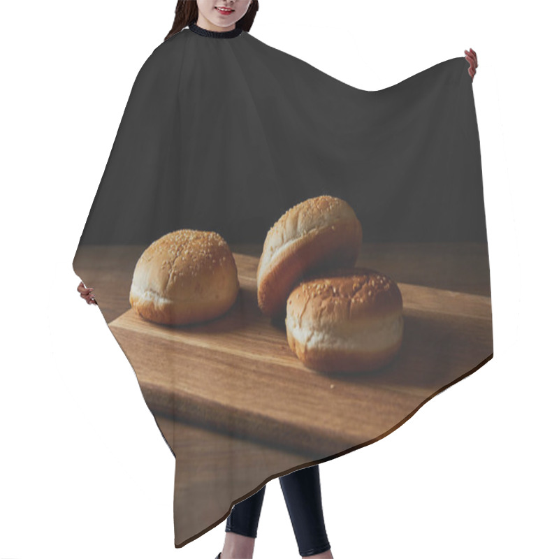 Personality  fresh tasty buns with sesame on wooden chopping board isolated on black hair cutting cape