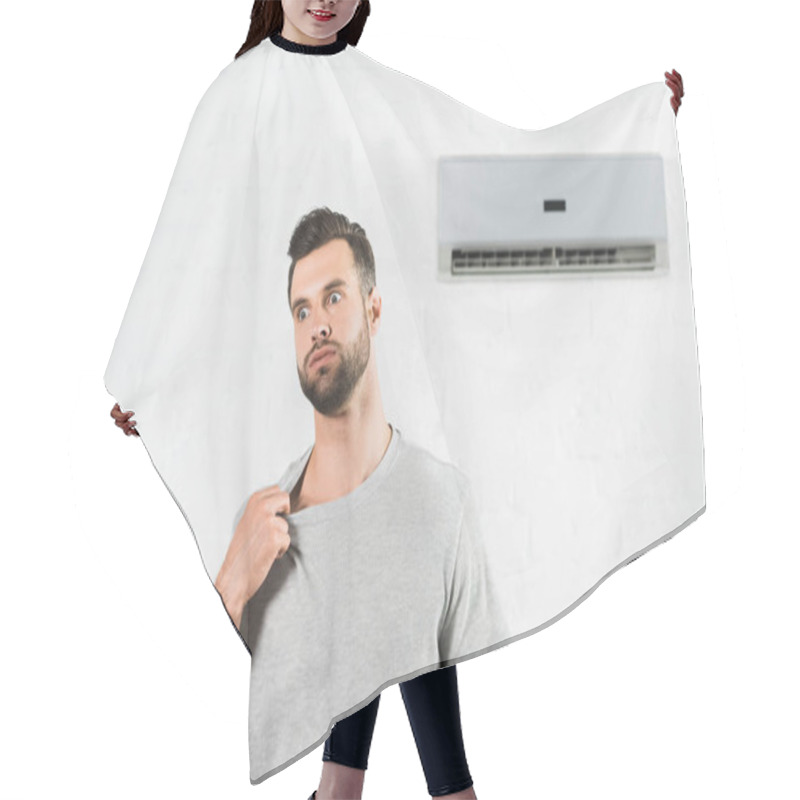 Personality  handsome man suffering from heat under air conditioner at home hair cutting cape