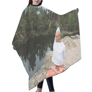 Personality  Buddhist In White Sweatshirt Meditating In Lotus Pose With Hands Behind Back On Rocky Cliff Over River Hair Cutting Cape