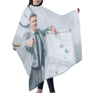 Personality  Cheerful Businessman Pointing At Camera While Standing Near Flipchart With Graphs  Hair Cutting Cape