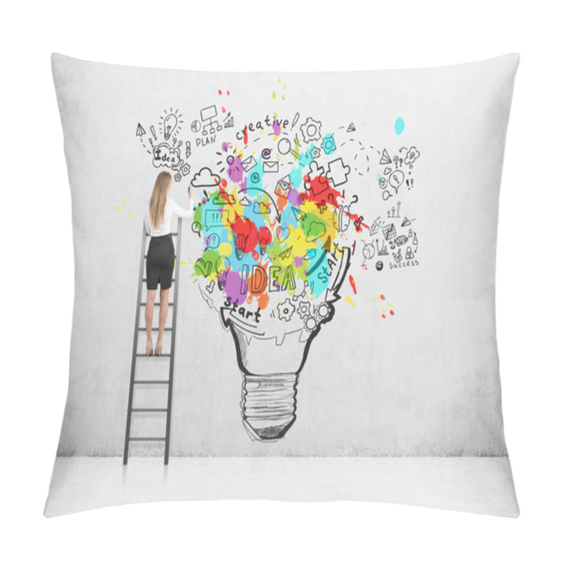Personality  Rear view of a blond woman standing on a ladder and drawing a large and colorful light bulb sketch on a concrete wall. pillow covers