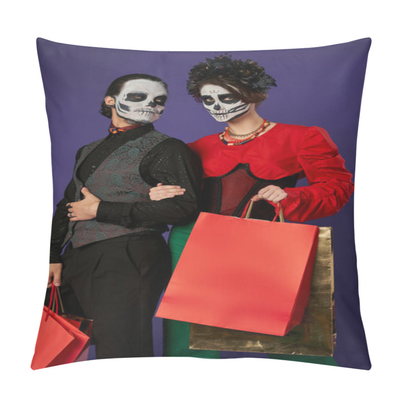Personality  couple in dia de los muertos makeup and festive attire holding shopping bags on blue, seasonal sale pillow covers