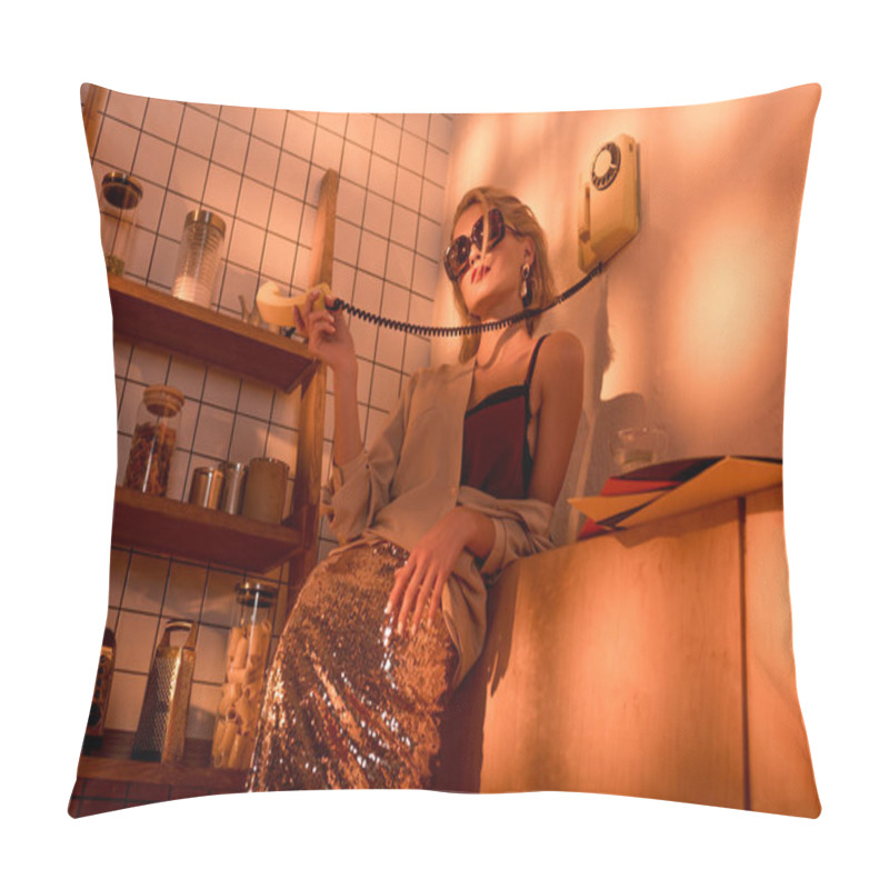 Personality  elegant woman in sunglasses holding retro telephone in kitchen with orange light pillow covers