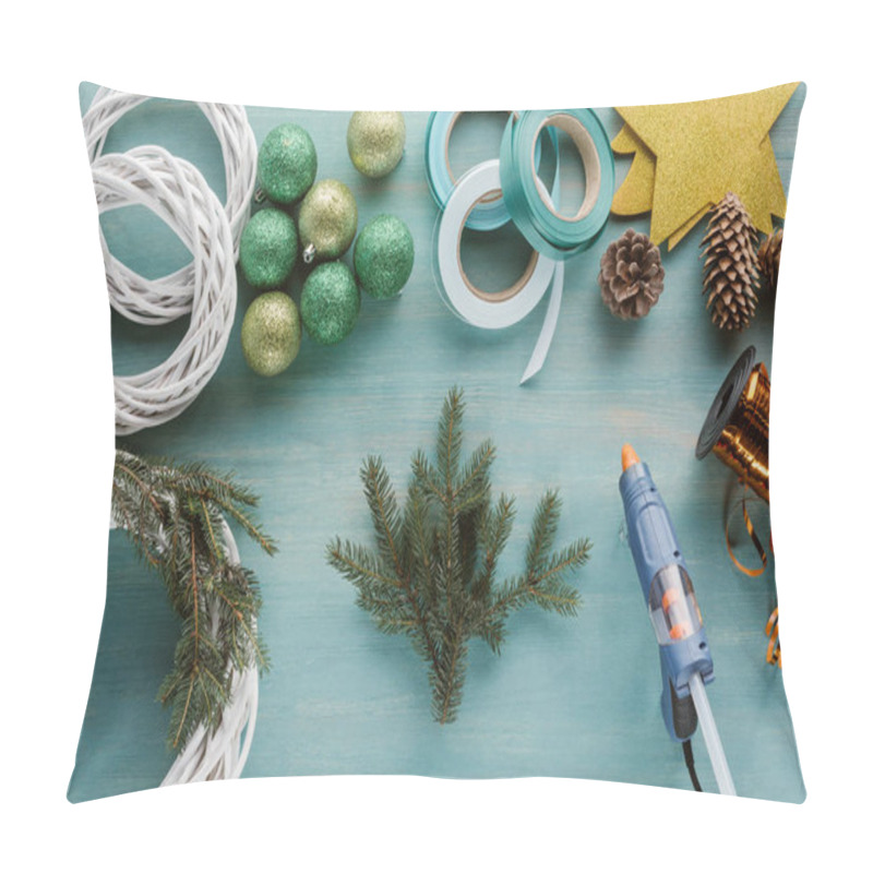 Personality  flat lay with christmas balls, pine tree branches and glue gun for handmade christmas wreath pillow covers