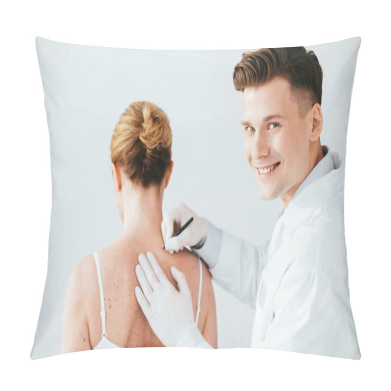 Personality  cheerful dermatologist in latex gloves holding marker pen near woman with melanoma isolated on white  pillow covers