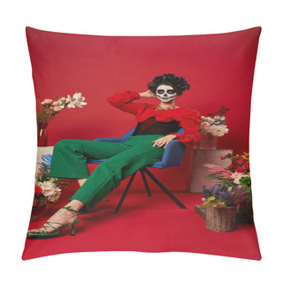 Personality  Woman In Dia De Los Muertos Makeup Sitting In Armchair Near Traditional Altar With Flowers On Red Pillow Covers