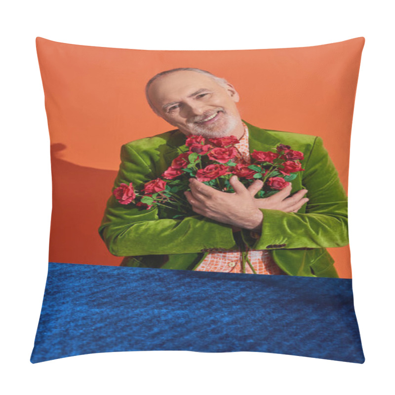 Personality  Overjoyed Senior Male Model In Green Velvet Blazer Embracing Bouquet Of Red Roses And Smiling At Camera Near Table With Blue Velour Cloth On Vibrant Orange Background, Happy Aging Concept Pillow Covers