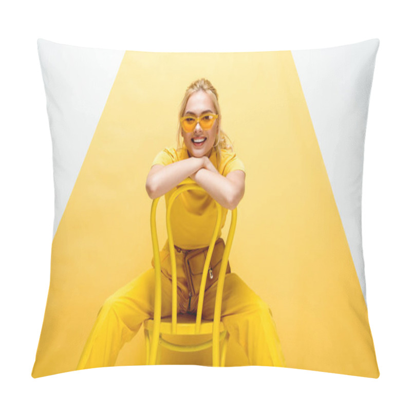 Personality  cheerful blonde woman in sunglasses sitting on chair on white and yellow  pillow covers