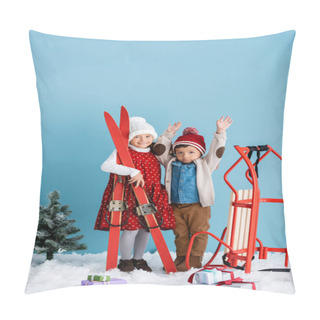 Personality  Girl In Winter Outfit Holding Skis Near Brother With Hands Above Head Standing Near Sleight And Presents On Snow Isolated On Blue  Pillow Covers