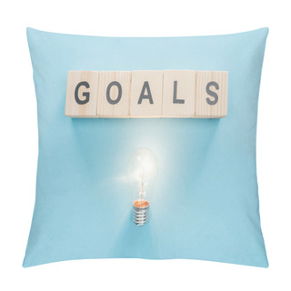 Personality  Top View Of Glowing Light Bulb Under 'goals' Word Made Of Wooden Blocks On Blue Background, Goal Setting Concept Pillow Covers
