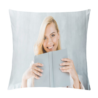 Personality  Happy Young Woman Holding Book And Smiling At Camera In Bedroom Pillow Covers