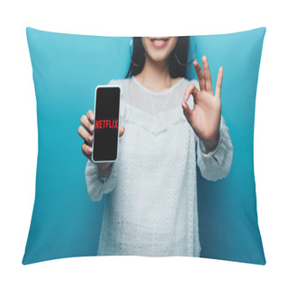 Personality  KYIV, UKRAINE - JULY 15, 2019: Cropped View Of Smiling Asian Woman In White Blouse Showing Ok Sign And Smartphone With Netflix App On Blue Background Pillow Covers
