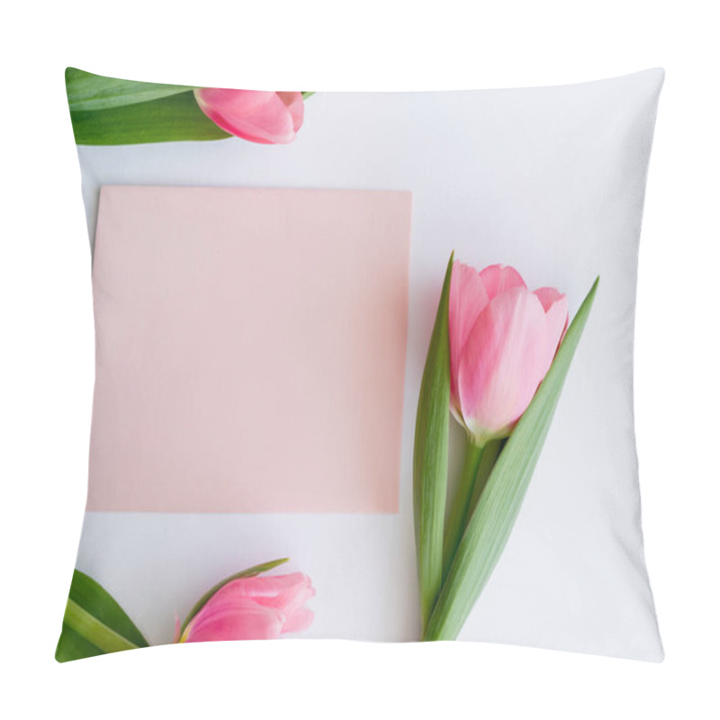 Personality  top view of pink tulips near pastel envelope on white pillow covers