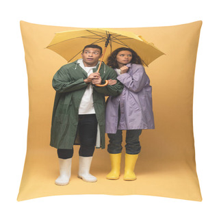 Personality  Scared Interracial Couple In Raincoats And Rubber Boots Holding Umbrella On Yellow Background Pillow Covers