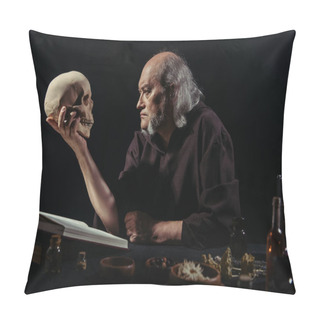 Personality  Senior Alchemist Looking At Skull Near Magic Cookbook And Herbal Ingredients Isolated On Black Pillow Covers
