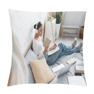 Personality  African American Student In Headphones Reading Book And Writing On Notebook Near Devices On Bed  Pillow Covers