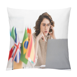 Personality  Concentrated Language Teacher In Glasses Looking At Laptop Near International Flags On Blurred Foreground  Pillow Covers