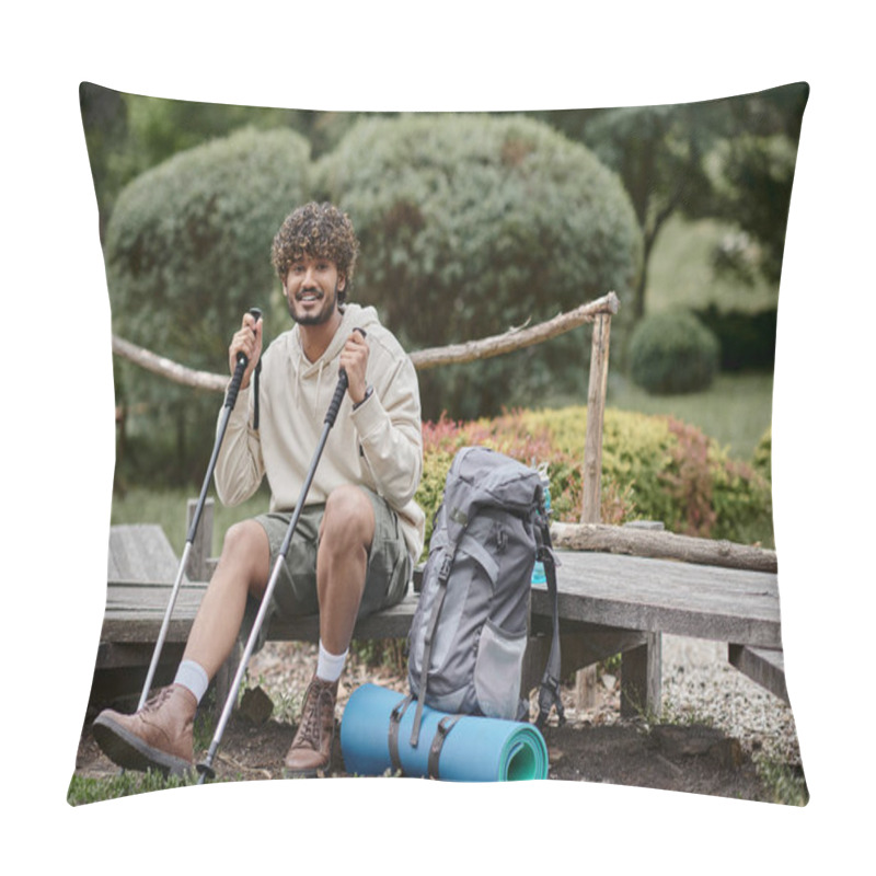 Personality  cheerful indian backpacker holding trekking poles and looking at camera in forest pillow covers