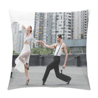 Personality  Smiling Man Holding Hand Of Partner While Dancing On Roof Of Building Outdoors  Pillow Covers