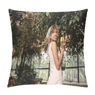 Personality  Smiling African American Woman With Braces In Trendy Summer Outfit Holding Ripe Lemon And Looking Away Near Trees In Garden Center, Stylish Woman With Tropical Plants At Backdrop Pillow Covers