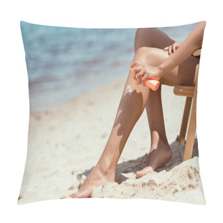 Personality  Cropped Image Of Woman Applying Sunscreen Lotion On Legs While Sitting On Deck Chair On Sandy Beach  Pillow Covers