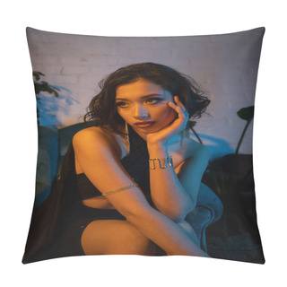 Personality  Stylish Asian Woman Holding Hand Near Cheek While Sitting On Armchair In Night Club With Lighting Pillow Covers