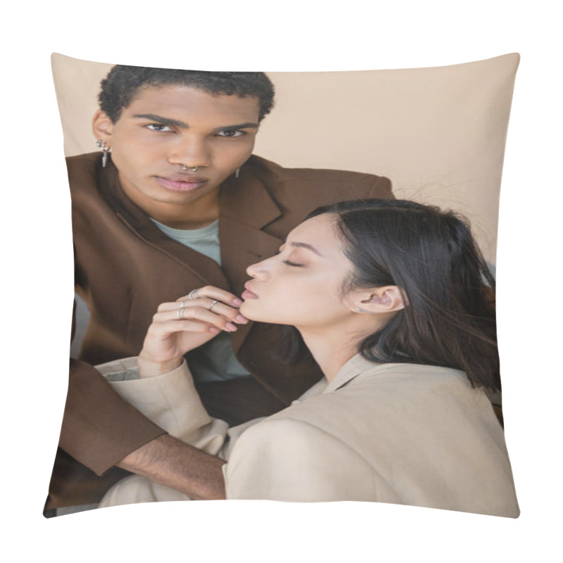 Personality  stylish african american guy with piercing looking at camera near young asian woman with closed eyes isolated on beige pillow covers