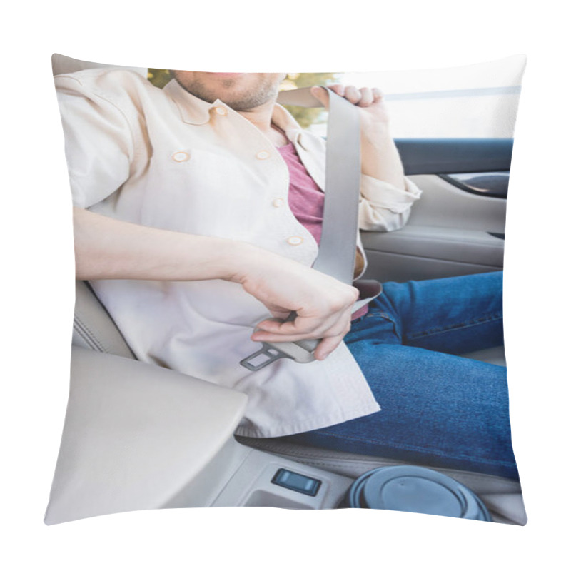 Personality  Cropped view of smiling man holding safety belt near coffee to go in car  pillow covers