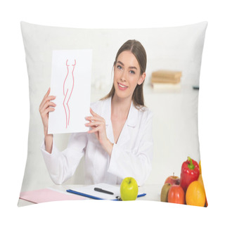 Personality  Smiling Dietitian In White Coat Holding Paper With Image Of Perfect Body At Workplace With Fruits And Vegetables On Table Pillow Covers
