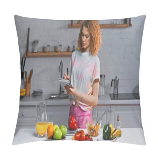 Personality  Curly Woman With Notebook Weighing Bell Pepper Near Vegetables And Orange Juice On Table  Pillow Covers