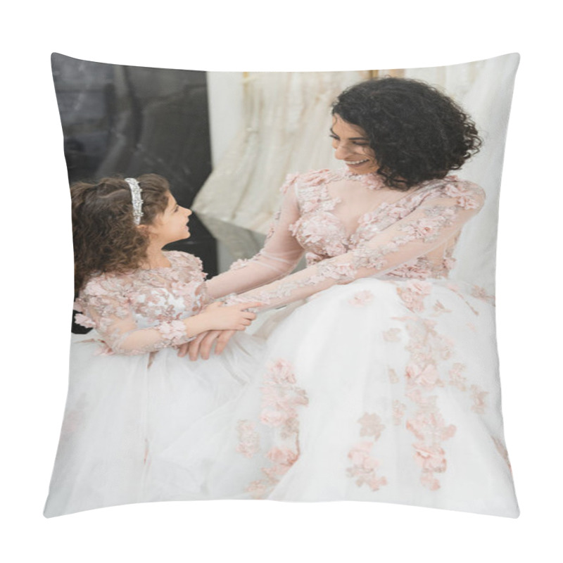 Personality  brunette middle eastern woman with wavy hair looking at girl and smiling near white wedding dresses in bridal salon, floral, mother and daughter, happiness, wedding day, shopping, bonding  pillow covers