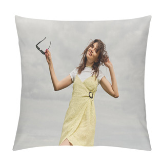 Personality  Low Angle View Of Cheerful And Stylish Brunette Woman In Sundress Looking At Camera And Holding Sunglasses While Standing With Cloudy Sky At Background, Summertime Joy Pillow Covers