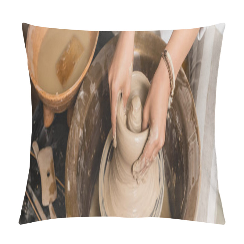 Personality  High angle view of young female potter molding wet clay while working with pottery wheel and bowl with water and sponge in ceramic workshop, pottery studio workspace and craft concept, banner pillow covers