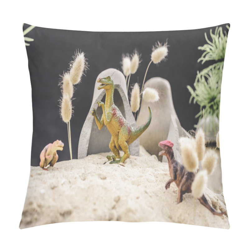 Personality  Selective Focus Of Toy Dinosaurs Standing Near Caves And Plants On Sand Dune  Pillow Covers