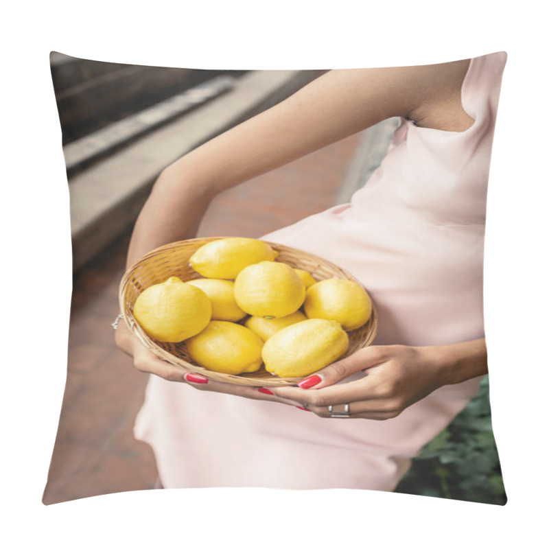 Personality  Cropped view of stylish african american woman in summer dress holding basket with ripe lemons while standing in blurred indoor garden, fashion-forward lady in harmony with tropical flora pillow covers